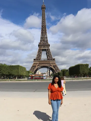 Nicole stands in front of the Eiffel Tower in Paris.
